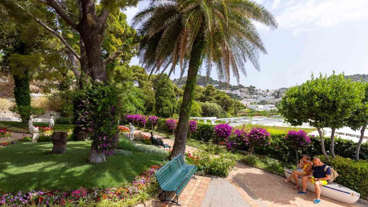 Giardini di Capri, con molti fiori e due persone sulla panchina